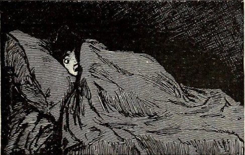 Child huddling under blankets in bed.